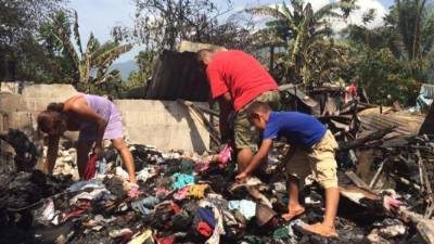 na de las familias afectadas busca entre los escombros del incendio.