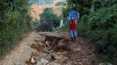 Un habitante camina en el lugar donde quedaron soterradas casas a cusa de las tormentas Eta e Iota en la aldea La Reina, el 16 de diciembre de 2020. EFE/ Germán Reyes/Archivo