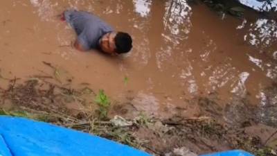 Un poblador intenta tapar la filtración del río Ulúa en Monterrey.