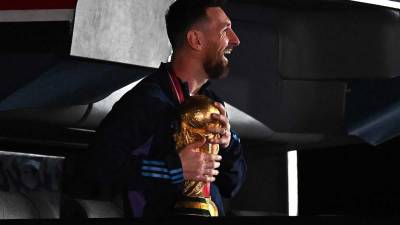 Lionel Messi, abrazado a la Copa del Mundo en la llegada de la selección argentina a Buenos Aires.