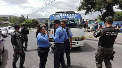 Policías y militares en el lugar de la escena del crimen en el que un conductor de un bus rapidito fue asesinado en Tegucigalpa, capital de Honduras. Fotos: tomadas del Twitter de Hoy Mismo.