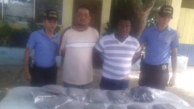 Los detenidos junto a la droga que se les decomisó.