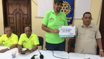 El rotario Raúl Cárcamo entrega el cheque a Raúl Cruz.