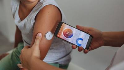 Una persona realiza monitoreo de glucosa a un niño.