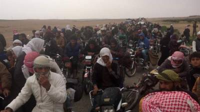 Un grupo de personas huye de los combates entre fuerzas de la coalición y miembros de ISIS. EFE/Archivo