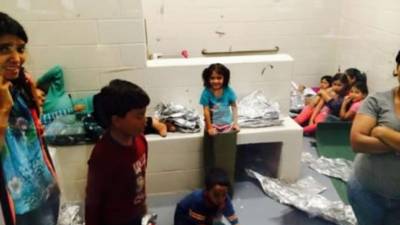 Los niños duermen en una bodega en contenedores de plástico, con una manta térmica como de papel de aluminio.