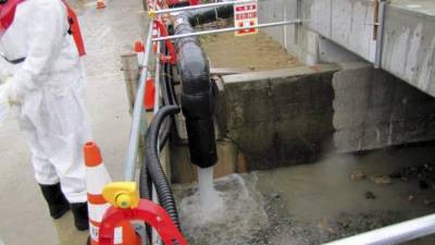 Un trabajador de Tokyo Electric Power (TEPCO) junto a un desagüe durante el vertido controlado al mar de agua con bajos índices de radiactividad en la central nuclear de Fukushima.