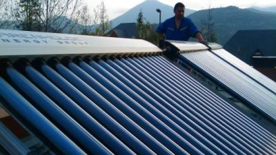 Un hombre instala paneles solares en un techo.