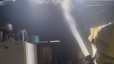 Uno de los bomberos termina de sofocar el fuego.