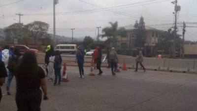 Momento en el que los universitarios encapuchados tapaban una calle en el bulevar Suyapa de Tegucigalpa, capital de Honduras.
