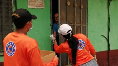 Voluntarios de Copeco durante la distribución de las mascarillas A3 en el barrio Cabañas.