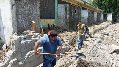 Albañiles contratados por la alcaldía sampedrana reconstruyen el muro del CEB José Azcona en la colonia San José de Chamelecón. Fotos: Jorge Monzón y Moisés Valenzuela.