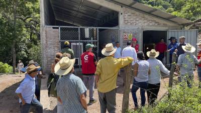 Habitantes observan la instalación del lugar donde se encuentran las baterías que son cargadas por paneles solares para un proyecto eléctrico, el 19 de octubre de 2023, en El Santuario (Honduras).