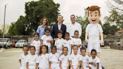 Grupo de niños con los ejecutivos Mario y Diana Faraj junto a Emilio Butragueño.