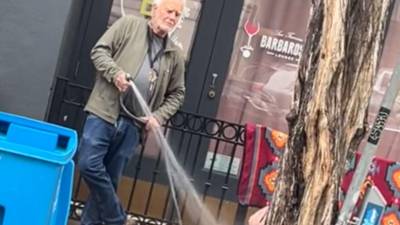 El video del hombre rociándole agua al indigente ha causado indignación en las redes sociales.