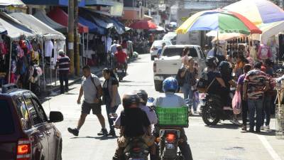 Hondureños transitan por el centro de San Pedro Sula.