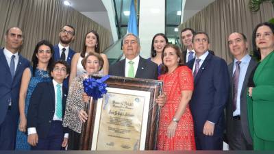 El empresario Emín Abufele junto a su familia muestra con orgullo el pergamino de Abanderado 2024 entregado por Banpaís como un reconocimiento a su destacada trayectoria en el país.