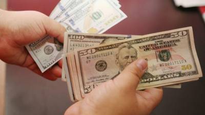 Un cajero bancario cuenta dólares.