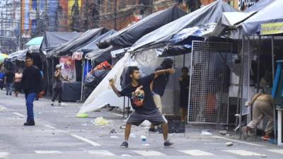 Uno de los vendedores lanza una piedra. El paso sobre la tercera avenida frente al parque central está cerrado.