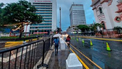 <b><span class=mln_uppercase_mln>Clima.</span></b> Dos mujeres caminan por el parque central de San Pedro Sula.