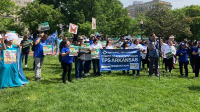 Personas sostienen pancartas a favor de la extensión del programa Estatus de Protección Temporal (TPS) durante una protesta en la plaza de Lafayette, hoy frente a la Casa Blanca en Washington (EEUU).