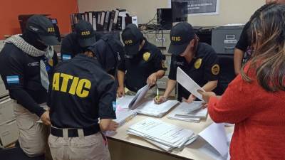 Personal de la Atic en las instalaciones del Dinaf revisando documentos.