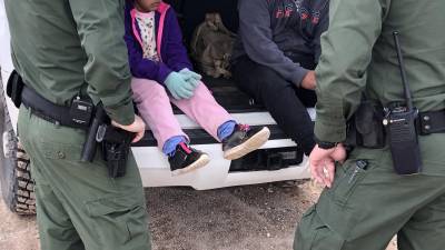 Fotografía de archivo donde aparecen dos agentes de la Patrulla Fronteriza mientras atienden a unos niños en un punto del área conocido como Quitobaquito, en la frontera de Arizona con México (EE.UU.)
