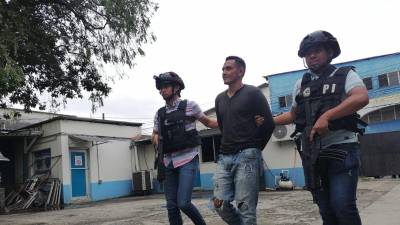 El detenido es resguardado por agentes policiales en San Pedro Sula.