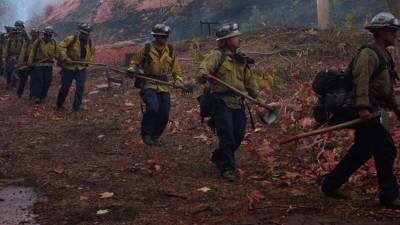 Fotografía de bomberos combatiendo el fuego en Palisades, Los Ángeles (EE.UU.).