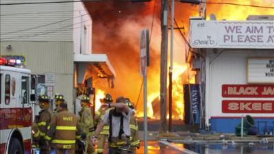 Fotografía cedida por The Star Ledger este 12 de septiembre de 2013, muestra a un grupo de bomberos mientras intentan apagar seis focos del incendio registrado en la parte sur del muelle de Seaside Park, en Seaside Heights en Nueva Jersey (EE.UU.). EFE