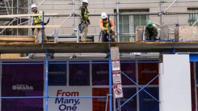 Trabajadores de la construcción instalan un andamiaje en un eidificio de Washington DC.
