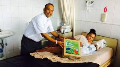 El ministro de la Secretaría de 'Mi Ambiente', José Antonio Galdames, al entregar el regalo a una mamá.