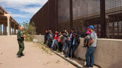 Un agente de la Patrulla Fronteriza requiere a un grupo de migrantes cerca de El Paso, Texas.