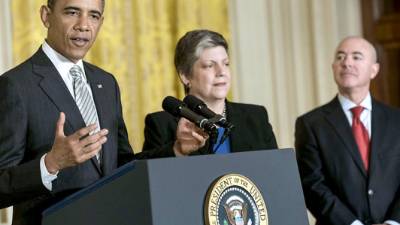 US Secretary of Homeland Security Janet Napolitano (C) and Alejandro Mayorkas (R), Director of United States Citizenship and Immigration Services, listen while US President Barack Obama speaks during a naturalization ceremony in the East Room of the White House on March 25, 2013 in Washington. Obama presided while Napolitano administered the oath of allegiance to active duty service members and civilians officially granting them United States citizenship. AFP PHOTO/Brendan SMIALOWSKI