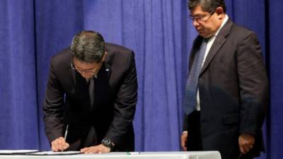 El presidente Juan Orlando Hernández sanciona las reformas. Observa el ministro Leonel Ayala.