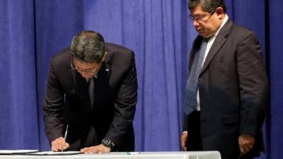 El presidente Juan Orlando Hernández sanciona las reformas. Observa el ministro Leonel Ayala.