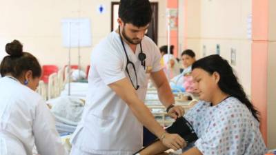 Estudiantes de quinto y sexto año de Medicina atienden a una dama que acababa de dar a luz en el hospital Leonardo Martínez de San Pedro Sula. Foto: Jordan Perdomo.