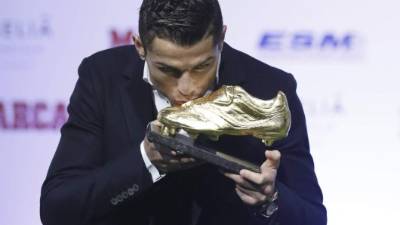 El delantero portugués del Real Madrid, Cristiano Ronaldo, besa su tercera Bota de Oro.
