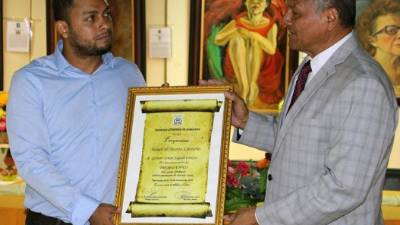 El escritor Gustavo Campos recibe el galardón de manos del presidente de la Sociedad Literaria de Honduras Luis Alonso Maldonado.