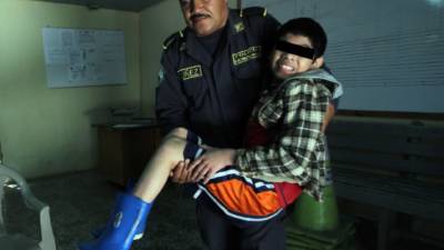 Un agente policial carga al pequeño encontrado abandonado en las cercanías de Eco Parque en El Zamorano.