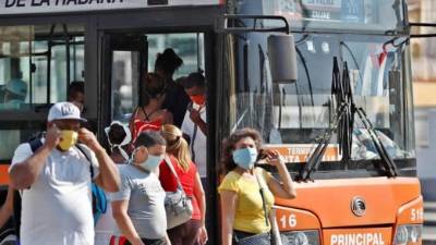 Ciudadanos usan tapabocas bajando de un ómnibus de transporte público, este martes, en La Habana (Cuba). EFE/ Yander Zamora