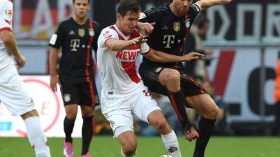 El mediocampista español Xabi Alonso supera en la marca a Daniel Halfar.