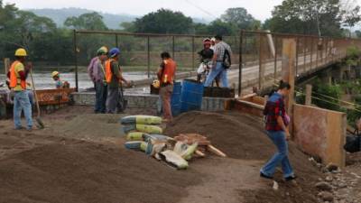 Personal de una empresa constructora trabaja a tiempo corrido para habilitar el paso.