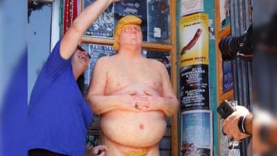 Una estatua desnuda del candidato republicano Donald Trump llama la atención de varios transeuntes, el pasado jueves 18 de agosto de 2016, quienes se fotografían con ella en Los Ángeles, EUA. EFE/Archivo