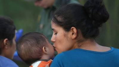 Una madre indocumentada besa a su hijo tras ser detenida por la patrulla fronteriza de EUA. Foto archivo.