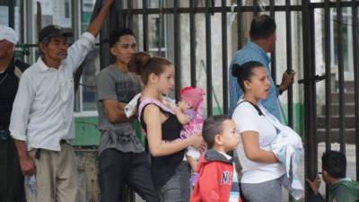 Trámite. Dos madres hacen fila para inscribir a sus hijos en el Registro Nacional de las Personas en SPS.