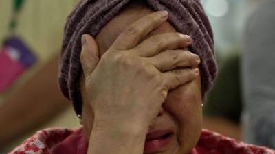 - Una mujer llora en el aeropuerto internacional de Kuala Lumpur, Malasia, en la ya madrugada allí del viernes 18 de julio de 2014.