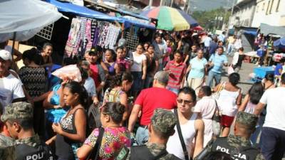 Agentes de la Policía Militar recorren un mercado sampedrano, pero los ciudadanos piden que se intensifiquen los esfuerzos porque lo hecho hasta el momento es insuficiente.