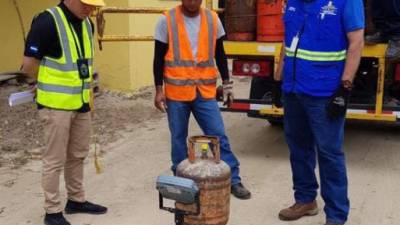 Personal del Ministerio Público y Protección al Consumidor pesan un cilindro de gas en un establecimiento de Choloma.