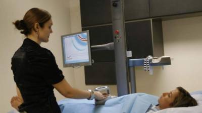 Una doctora examina el abdomen de una paciente en un hospital salvadoreño.